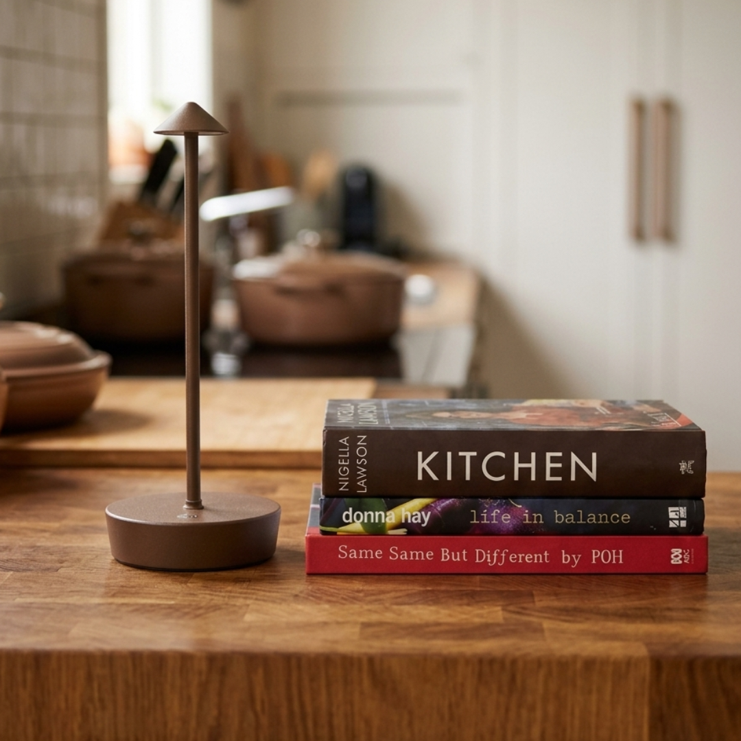 Brown halo light with stack of cookbooks on a kitchen counter